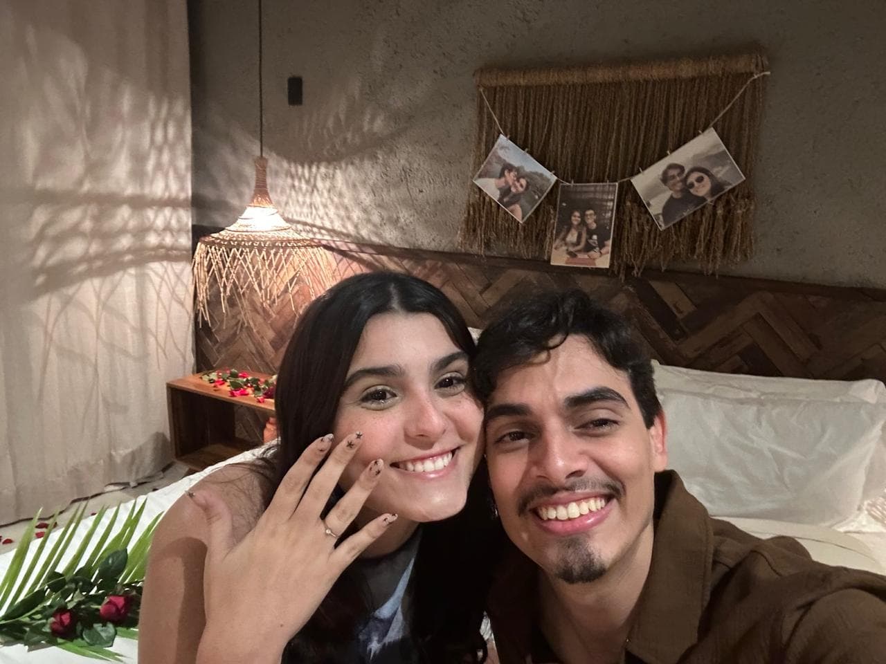 Marina mostra a aliança de noivado ao lado de Lucas em um quarto decorado