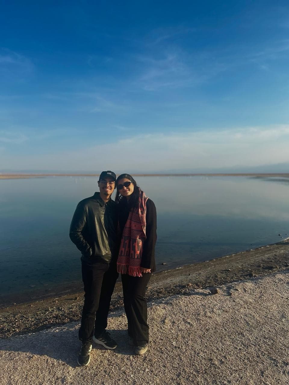 Lucas e Marina em frente a uma laguna no deserto do Atacama